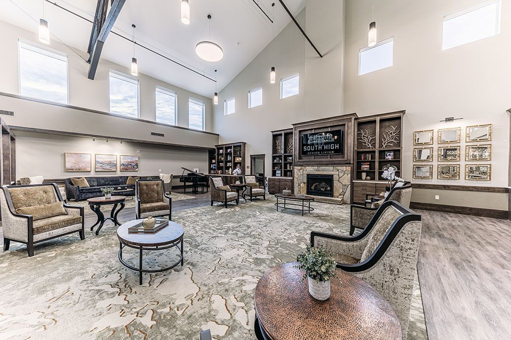 A spacious and elegantly designed lobby featuring a seating area with modern furniture, a fireplace, and large windows.