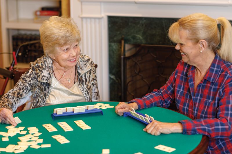 Two seniors enjoying a card game together at a table.