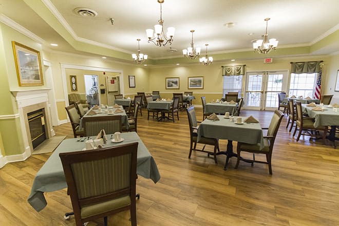 An elegant dining room setup with neatly arranged tables and chairs, ready for guests.