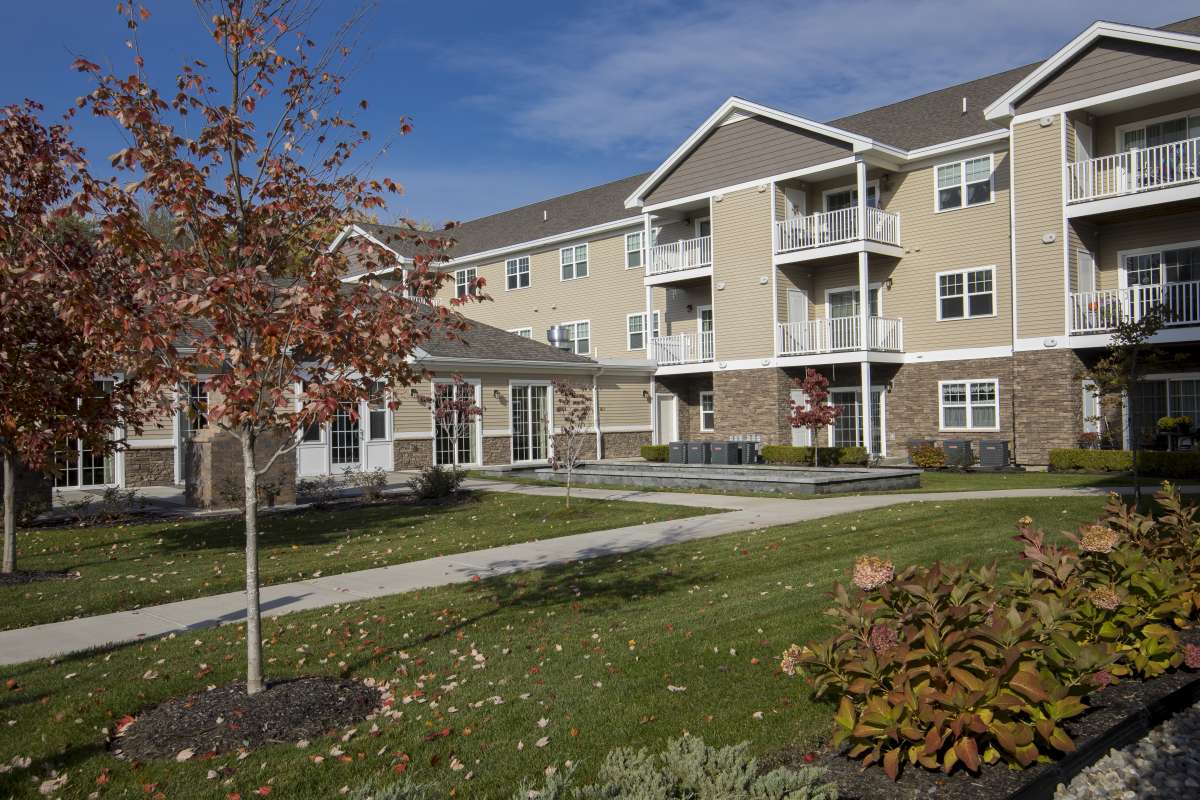 A modern apartment complex with well-maintained landscaping and balconies.