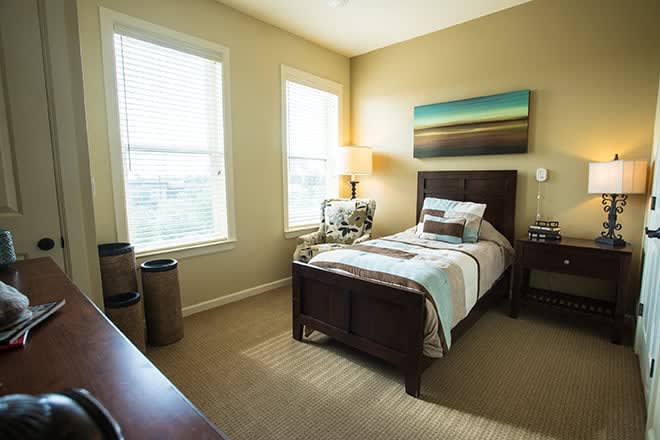 A cozy bedroom with a single bed and warm lighting.