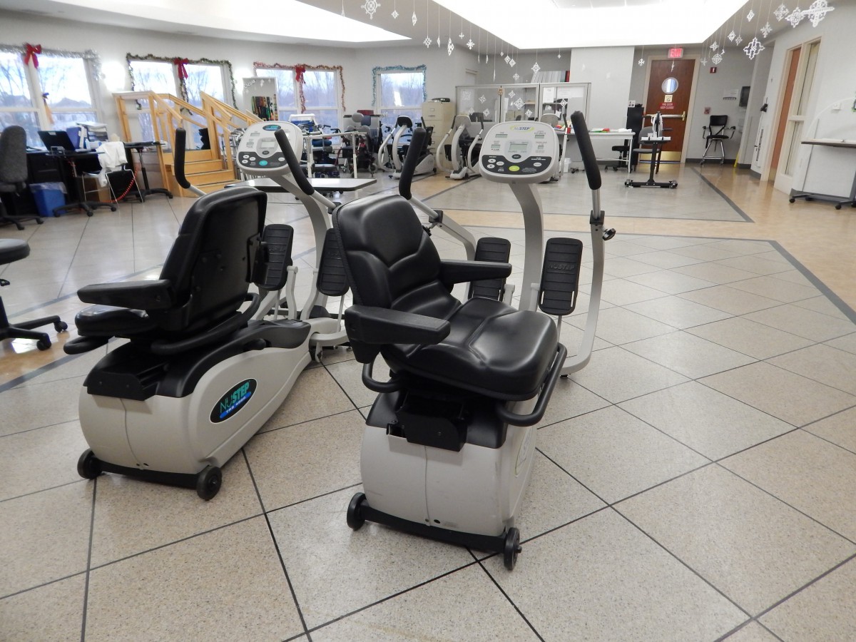 A spacious fitness center featuring several recumbent exercise bikes.