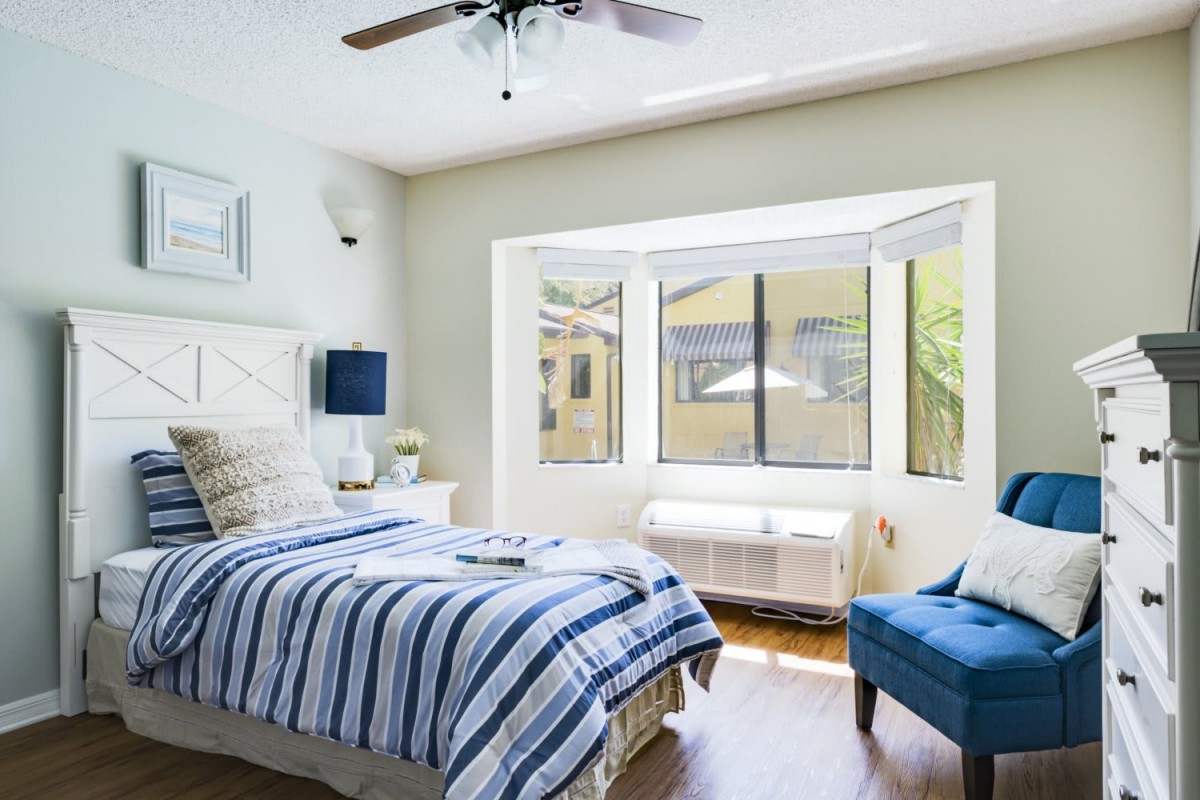 Bright and cozy bedroom with striped bedding and a window seat.