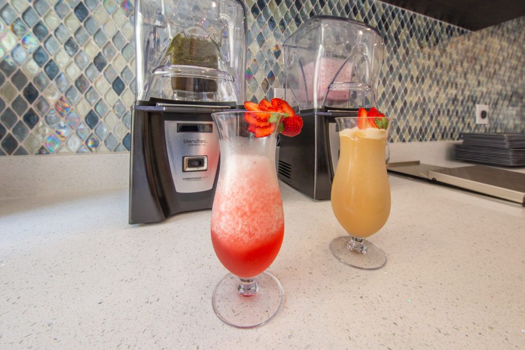 Colorful smoothies topped with fresh strawberries sit on a kitchen counter, ready to enjoy.