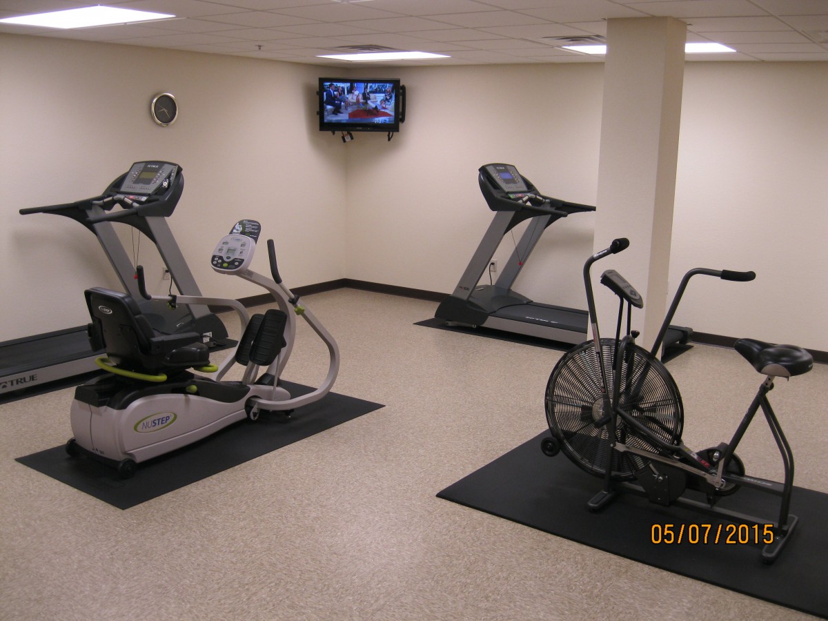 An indoor gym with treadmills, an elliptical machine, and a stationary bike.