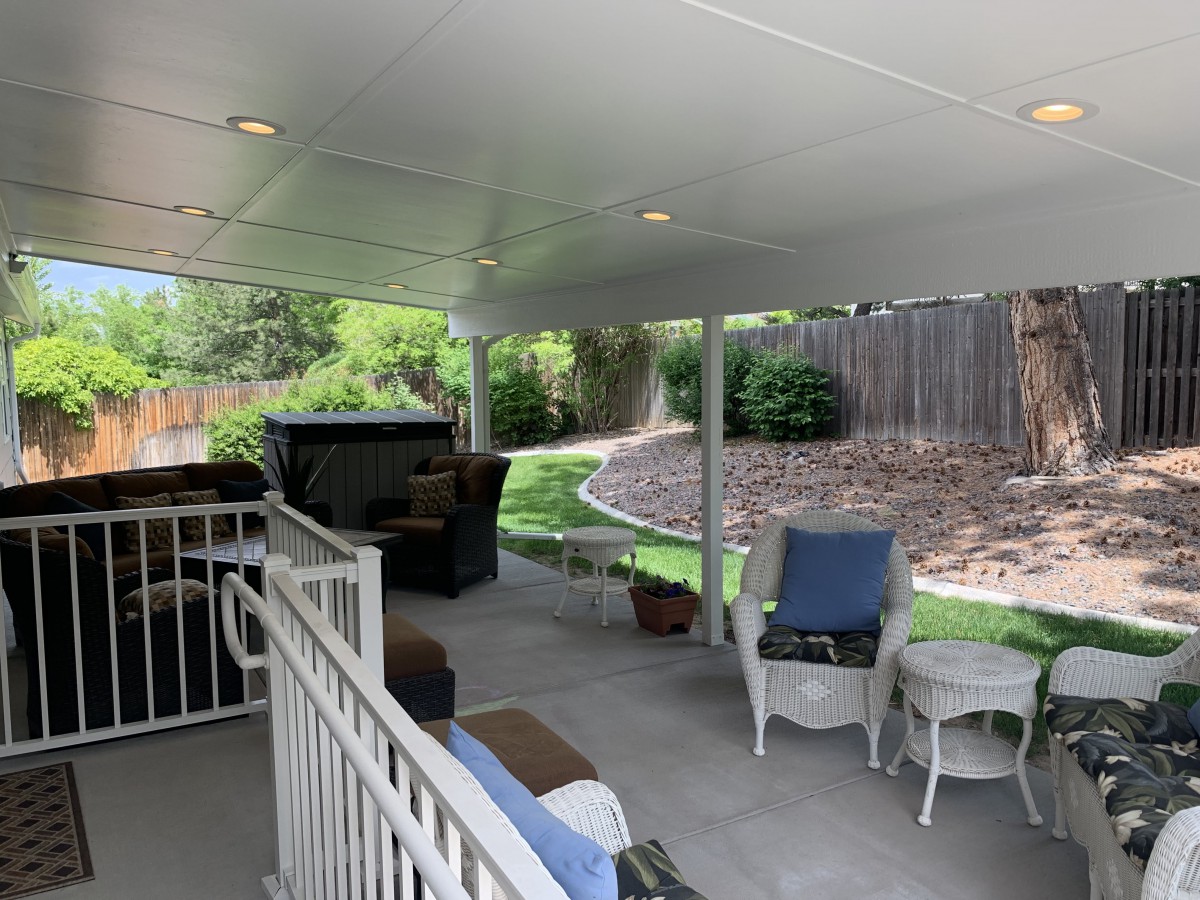 A cozy backyard patio with seating and a covered area.
