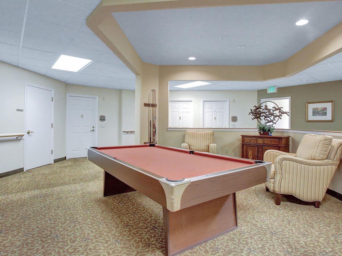 A cozy recreation room featuring a pool table and comfortable seating.
