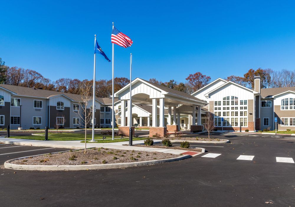 A modern building with flagpoles and a clear blue sky in the background.