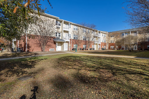 A sunny view of a residential apartment building surrounded by greenery.