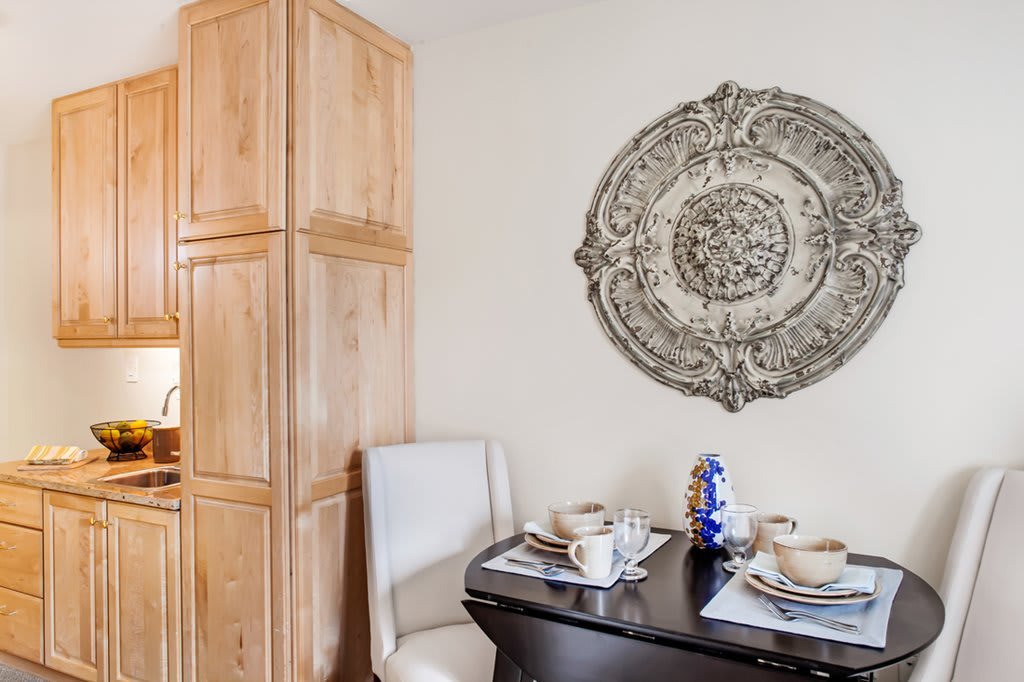 Cozy dining area with a decorative wall piece and neatly set table.