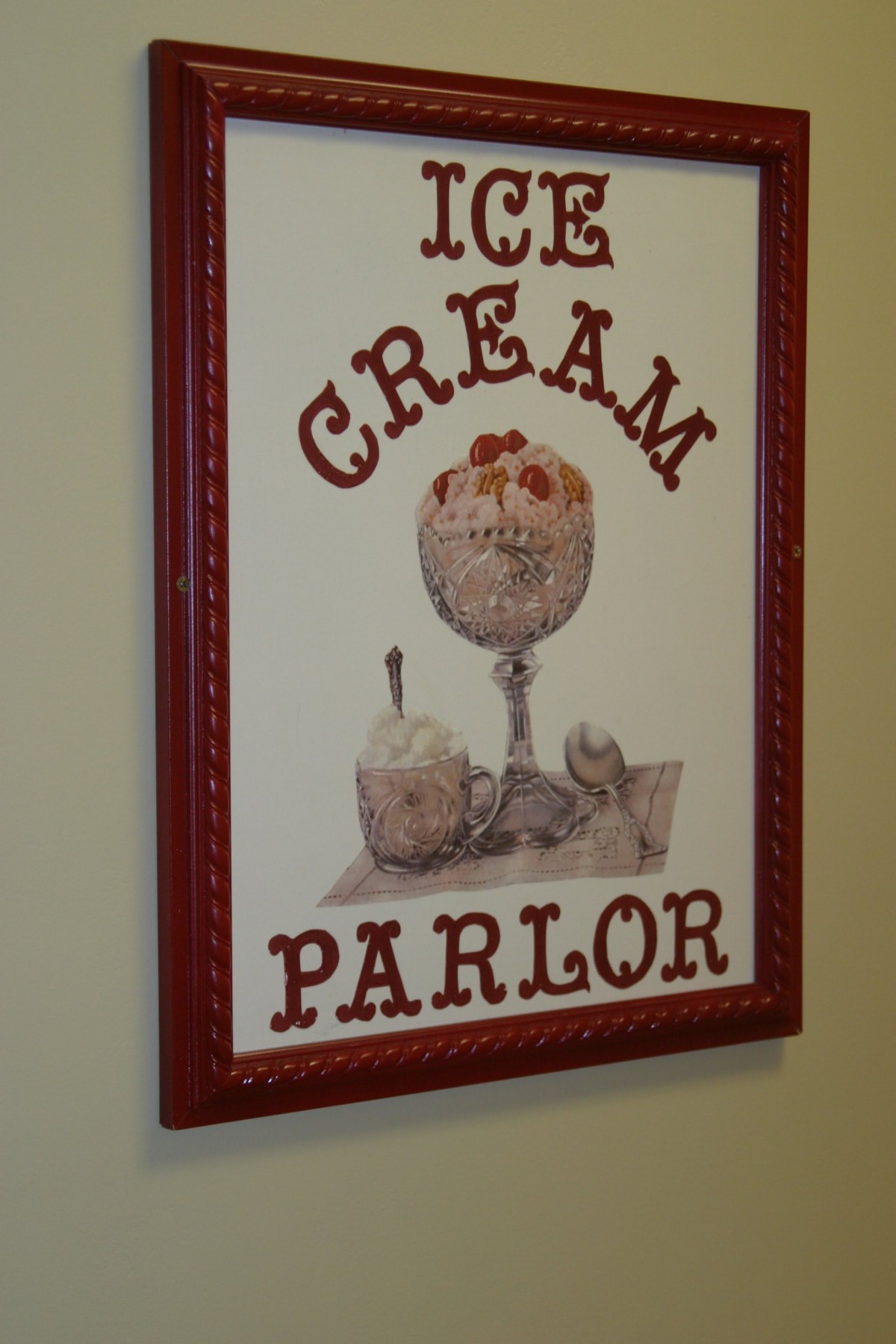 A decorative sign for an ice cream parlor featuring illustrations of desserts.