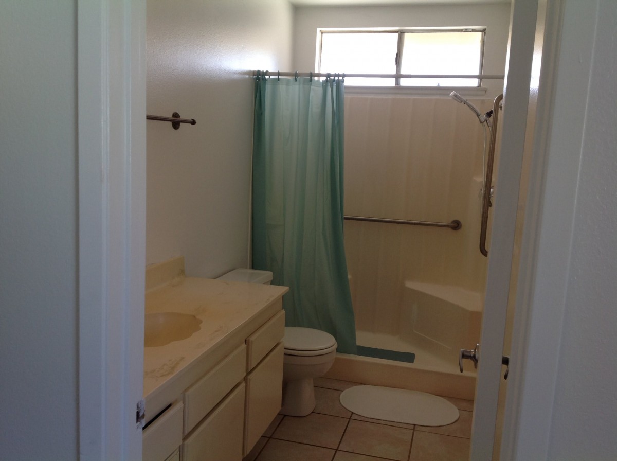 A small bathroom with a shower, toilet, and sink.
