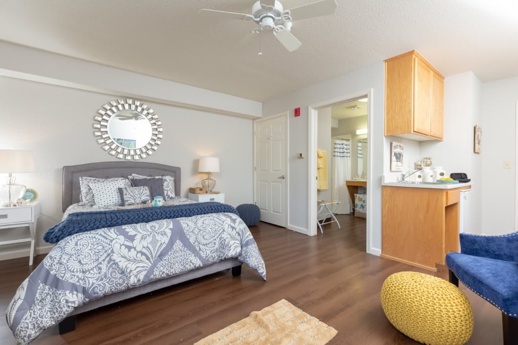 A cozy and modern bedroom with elegant decor, featuring a comfortable bed, stylish furniture, and a decorative mirror on the wall.