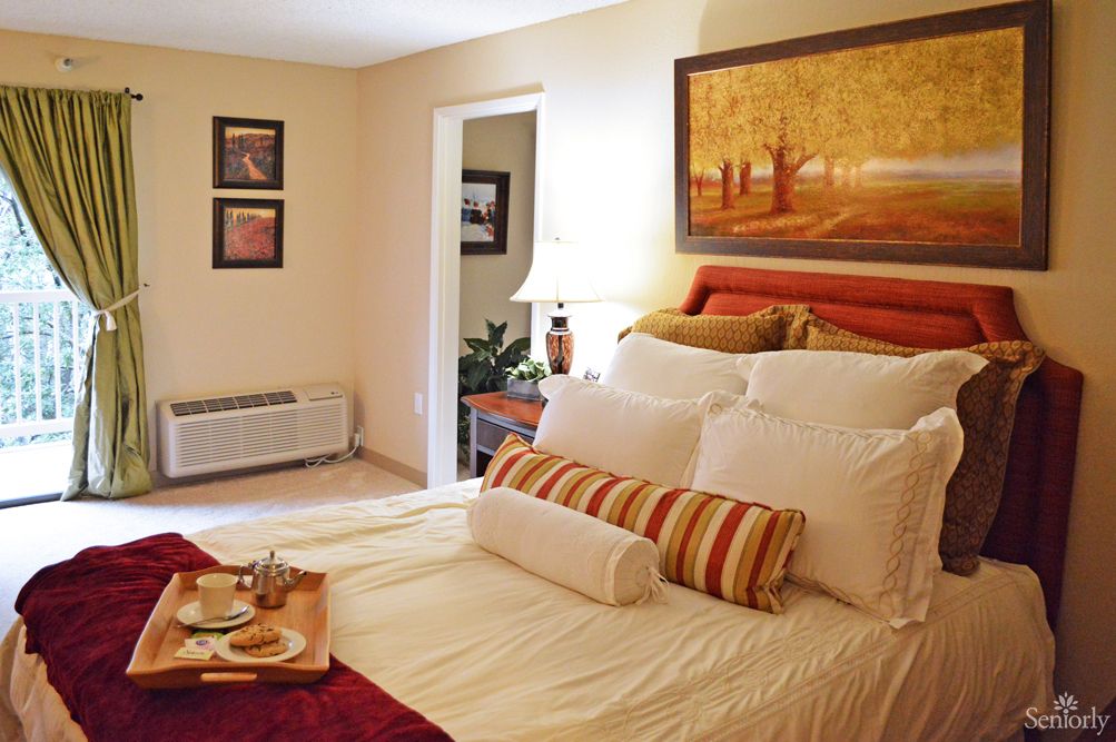 A cozy bedroom with a well-decorated bed and wall art.