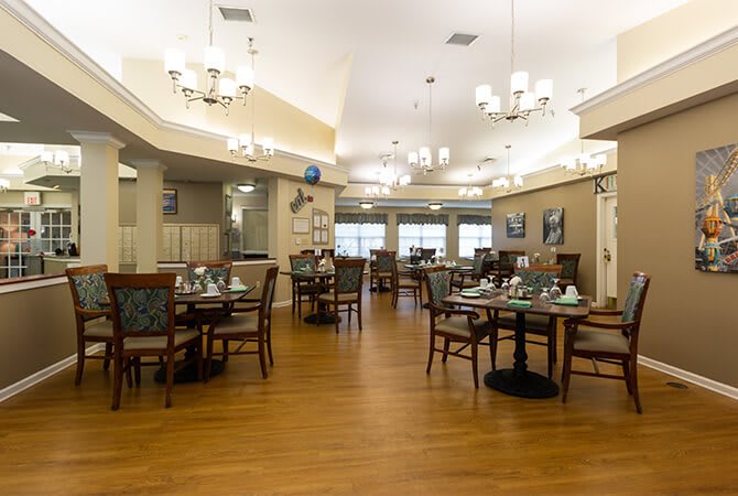 A well-lit dining area with neatly arranged tables and chairs in a restaurant setting.