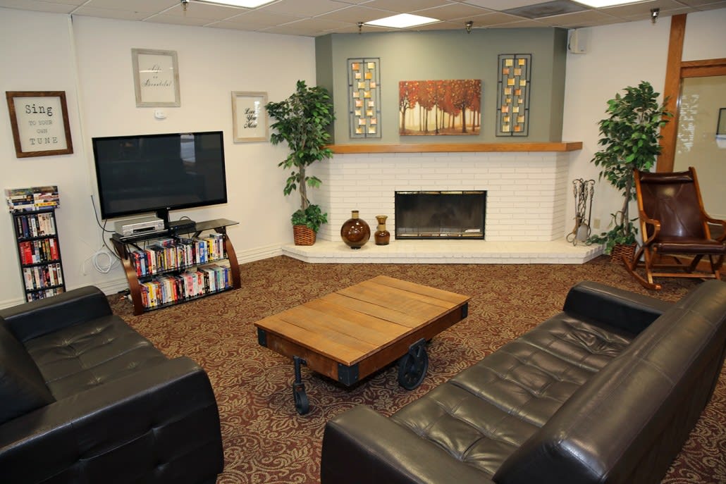 A cozy living room featuring a fireplace, television, and a comfortable seating area with decorative elements.