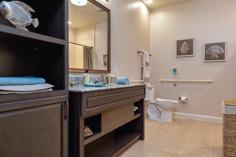 A modern bathroom with a sink, mirror, and toilet, featuring stylish home decor.