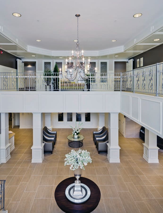 A luxurious modern lobby with a chandelier and elegant decor.