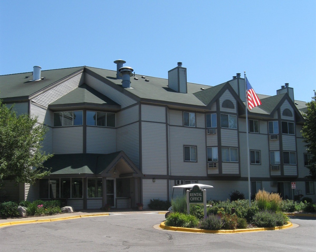 A hotel building with an American flag in front, captured on a clear day.