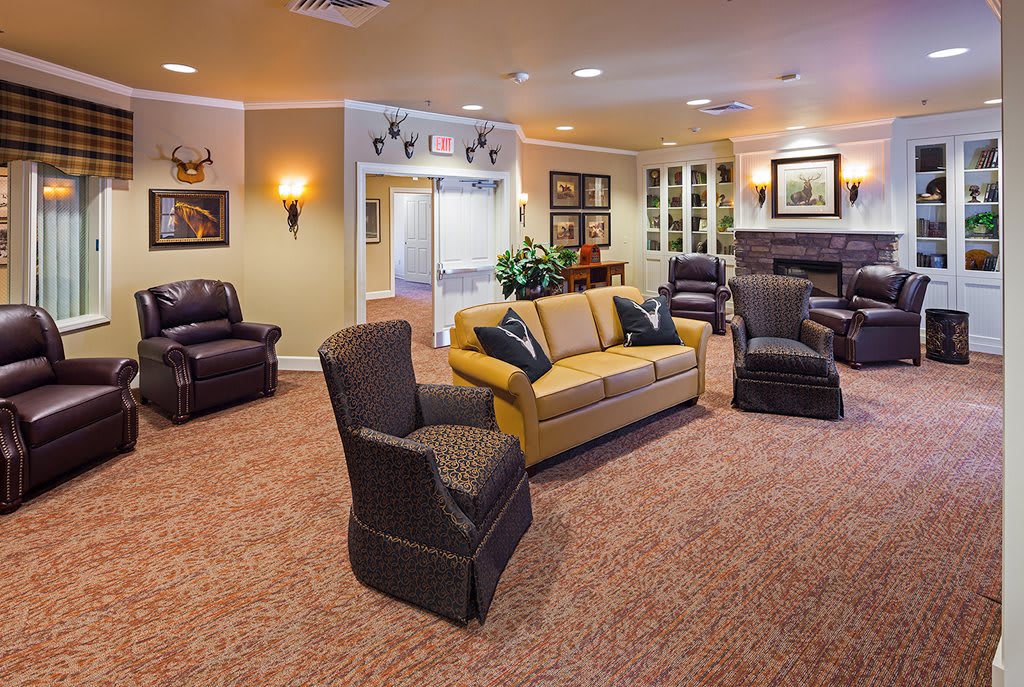 A cozy living room with multiple armchairs and a sofa arranged on carpeted flooring.