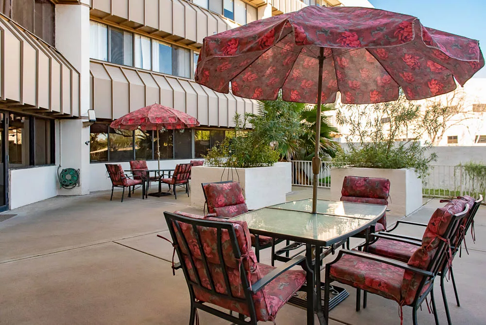 An outdoor patio area with tables and chairs under large umbrellas.
