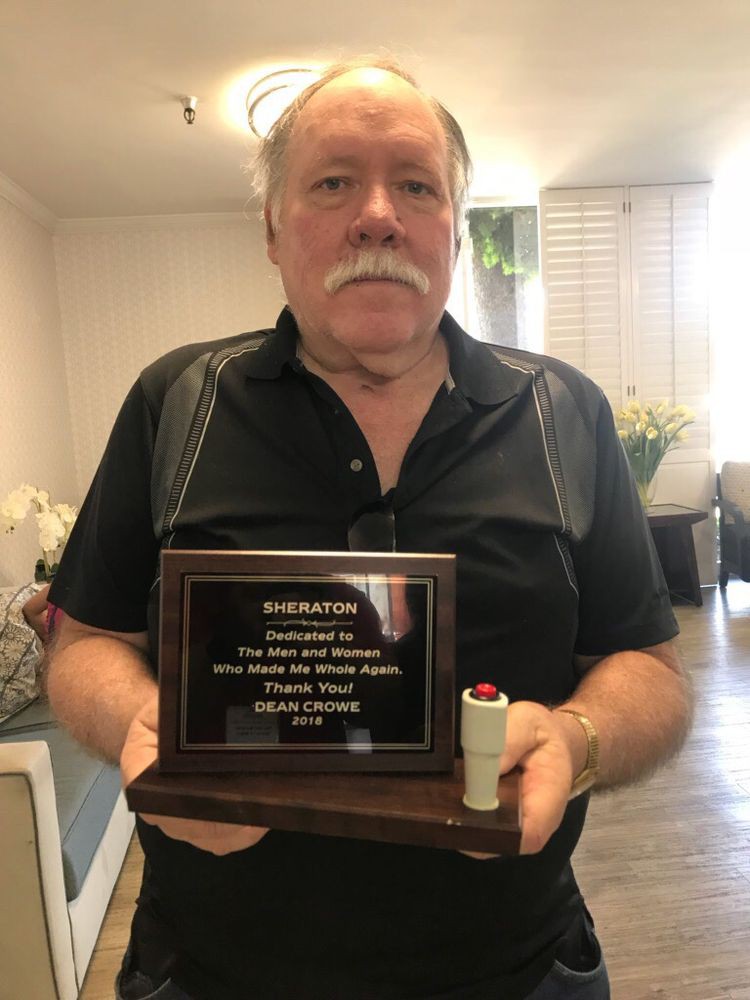 Man holding an award plaque indoors