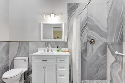 A modern bathroom featuring a sleek vanity, marble accents, and an elegant shower area.
