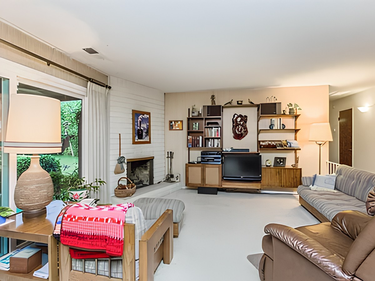 A cozy living room with retro decor featuring a television, fireplace, and comfortable seating.