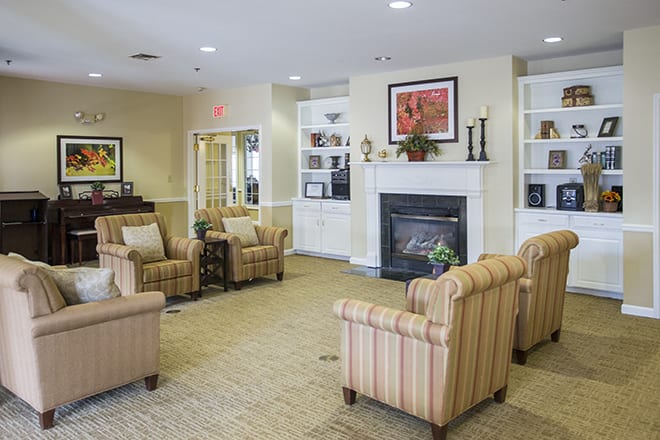 A cozy living room with a seating area around a fireplace.