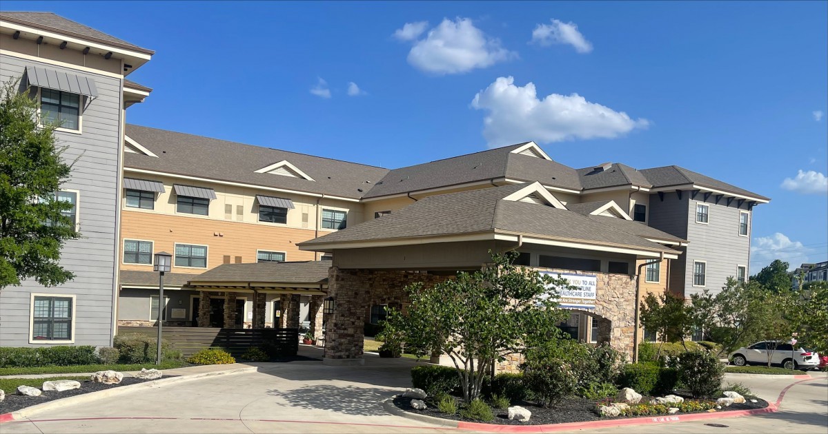 A hotel building under a clear blue sky with scattered clouds.