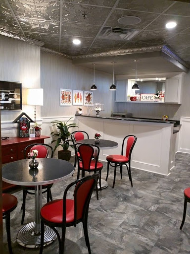 A stylish caf interior featuring red chairs, modern furniture, and contemporary wall art.