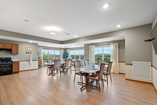 A spacious and inviting dining area featuring modern furnishings, large windows that allow ample natural light, and a cozy atmosphere for gatherings.