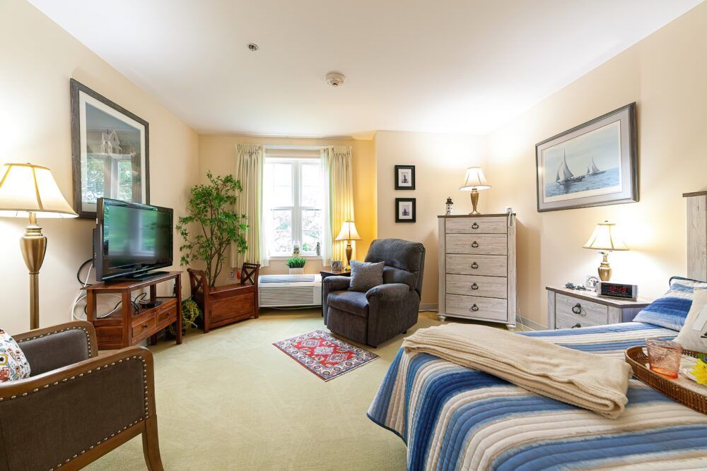 A cozy bedroom with comfortable seating, a TV, and decorative elements.
