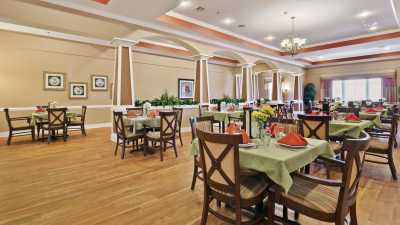 An elegant dining area with neatly arranged tables and chairs, featuring tasteful decor and a warm atmosphere.
