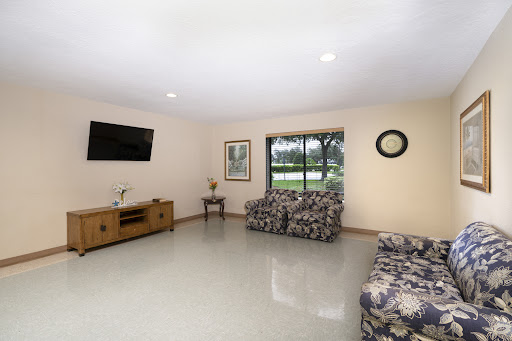 A spacious and well-lit living room featuring comfortable seating and a large window for natural light.