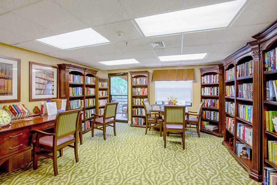 A cozy library with bookshelves, tables, and chairs for reading and studying.