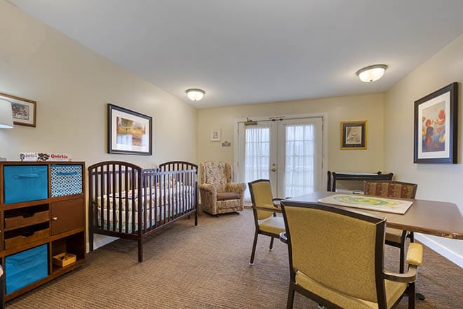 A cozy interior room featuring a crib and a small dining area.
