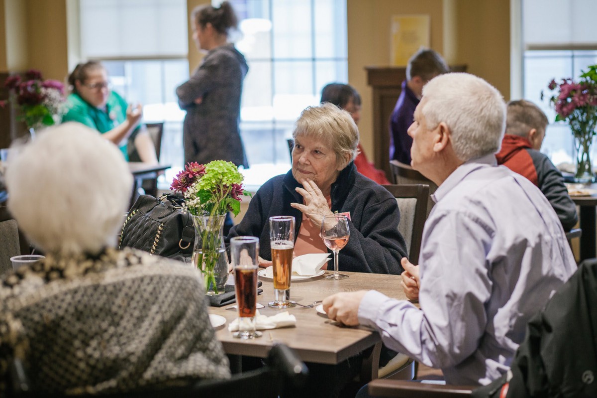 Seniors enjoying a meal and conversation at a social gathering.