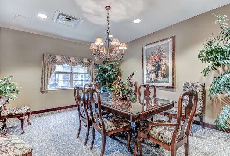 A formal dining room with a chandelier, elegant wooden table and chairs, and decorative wall art.