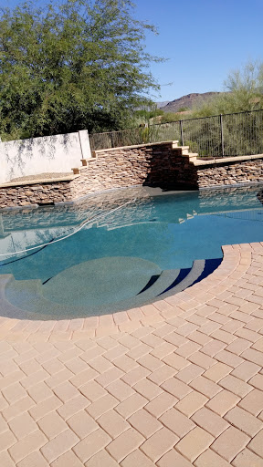 A serene outdoor pool with a stone backdrop, perfect for relaxation.