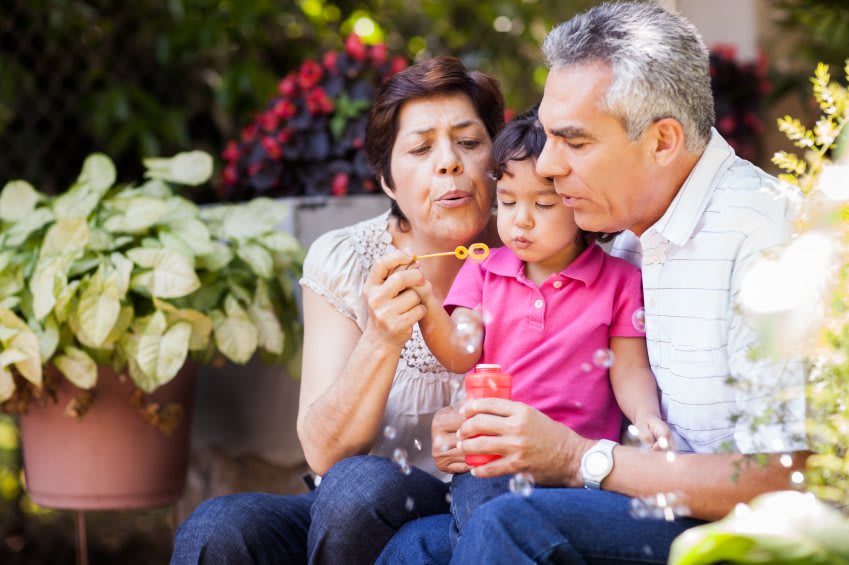 A child enjoying bubble time with grandparents in the garden.