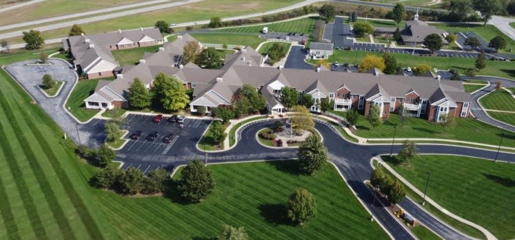 Aerial view of a complex surrounded by landscaped greenery and roads.