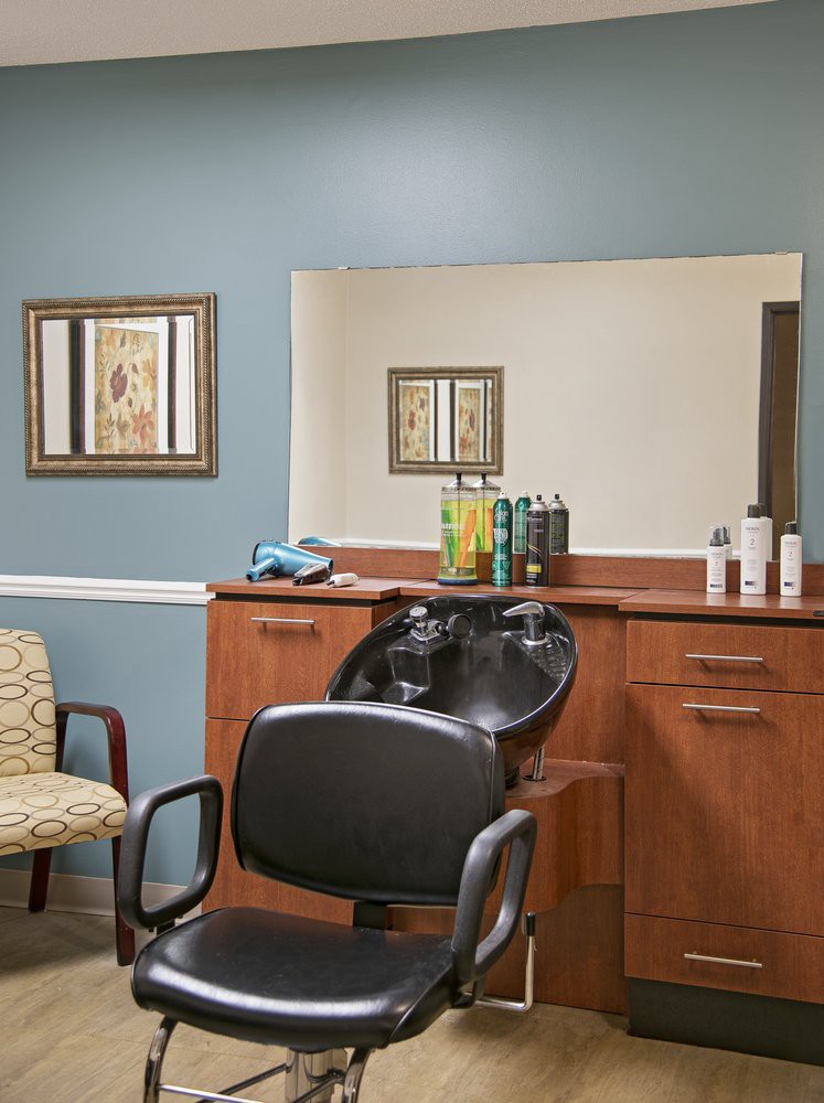 A hair salon with a styling station, mirror, and various hair care products.