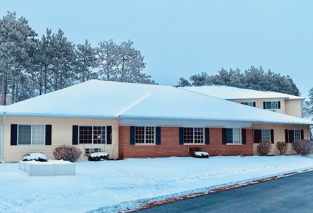 A snow-covered house in a winter landscape.