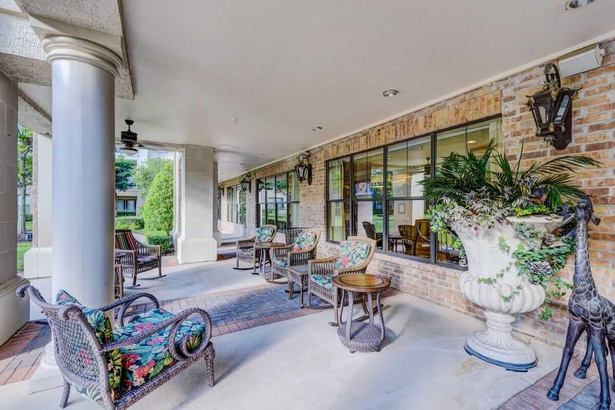 A spacious covered patio with comfortable seating and lush plants.