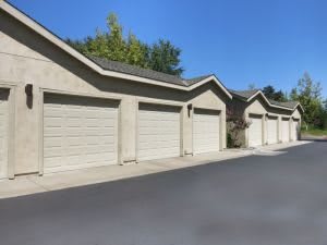 A row of garages with closed doors under a clear blue sky.