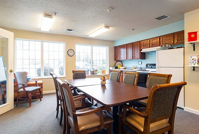 A cozy dining area with a table and chairs adjacent to a kitchen.