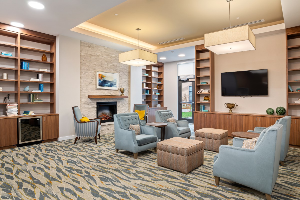 A modern living room featuring comfortable seating, a fireplace, and built-in bookshelves.