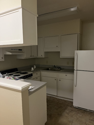 A clean and modern kitchen featuring white cabinetry and essential appliances.