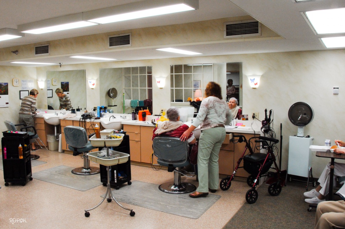 A hair salon where seniors are getting their hair styled by a hairdresser.